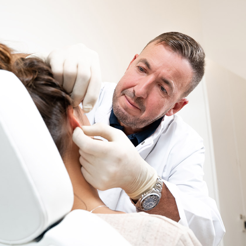 Dr. Horn untersucht das Ohr einer Patientin in der Praxis HNO am Neckar. 