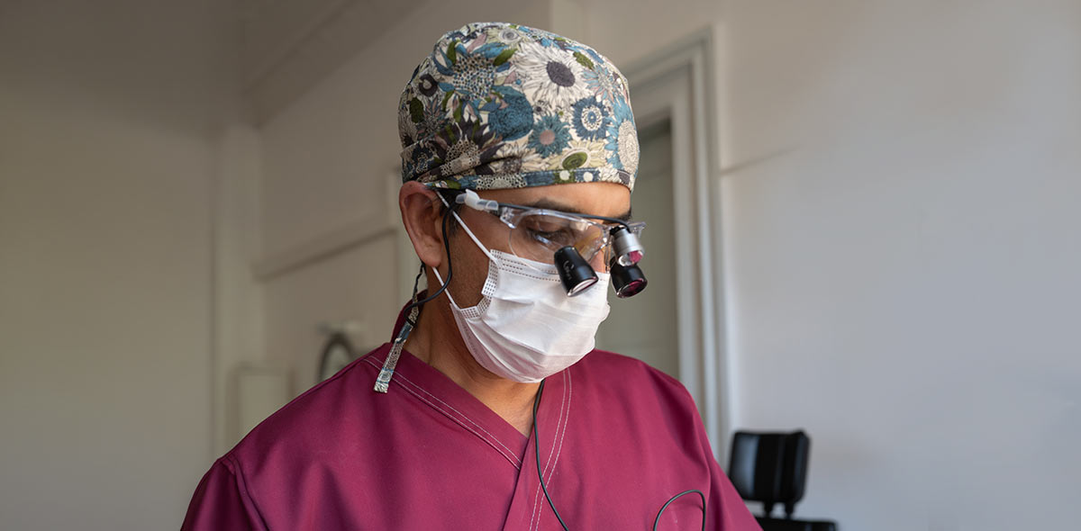 Dr. Choudhry mit OP-Haube, Mundschutz und Lupenbrille